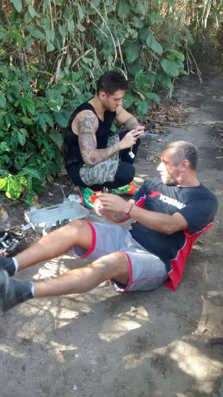 Lucas Lucco no celular enquanto mecânico conserta o carro. Foto: Extra