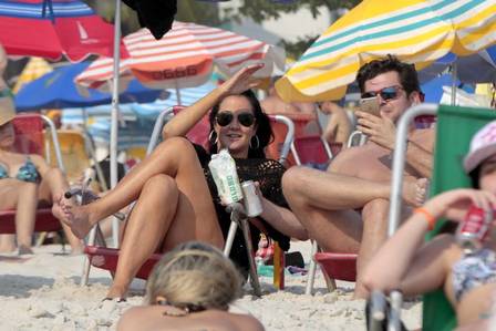 Helen Ganzarolli curte praia com novo namorado comendo biscoito de polvilho com champanhe