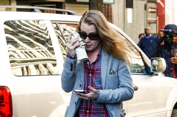 Macaulay Culkin, com os cabelos compridos, evita flashes nos EUA