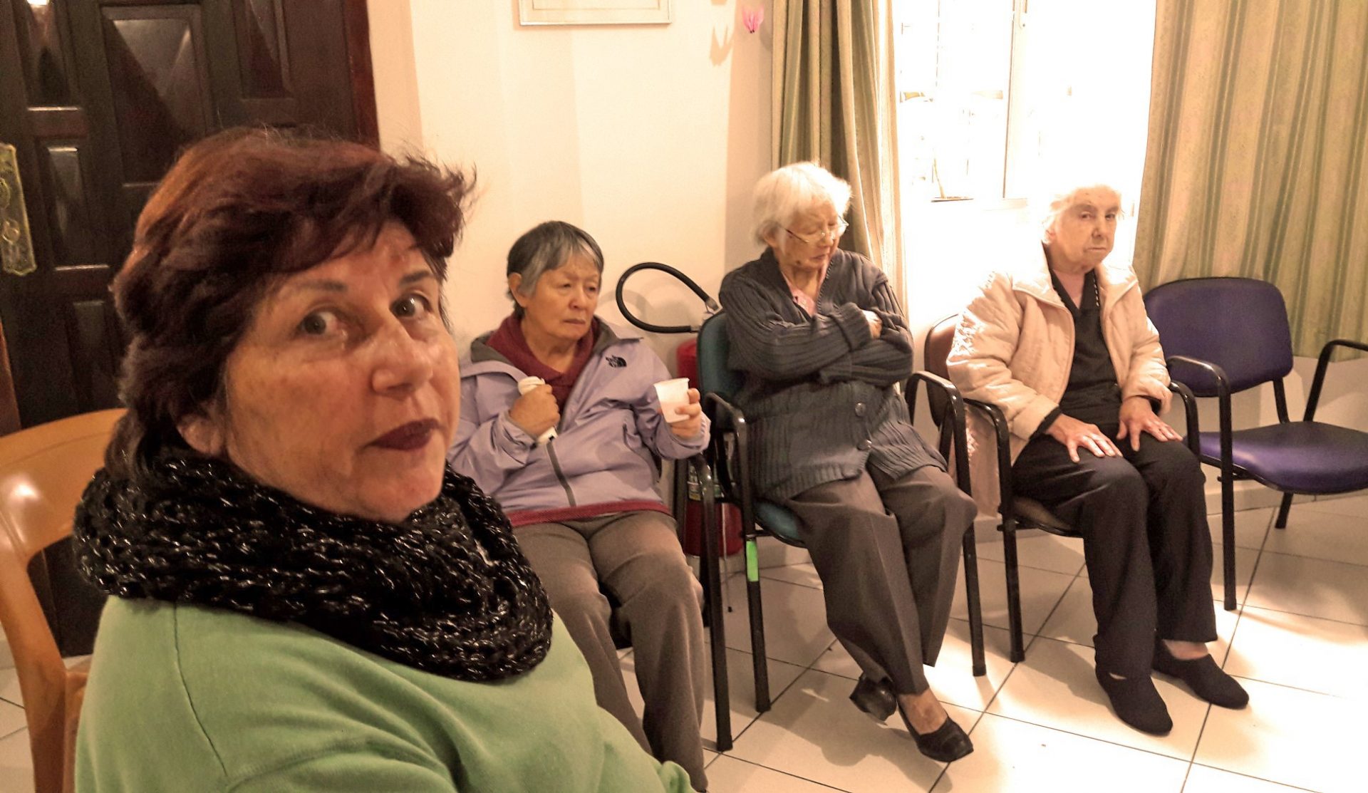 A voluntária Cleide Colombo ao lado de idosos assistidos pelo Centro Dia do Idoso Fragilizado. Foto: Band/Divulgação